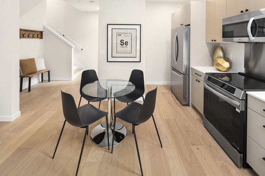 Kitchen and dining area with a small round table and white oak floor