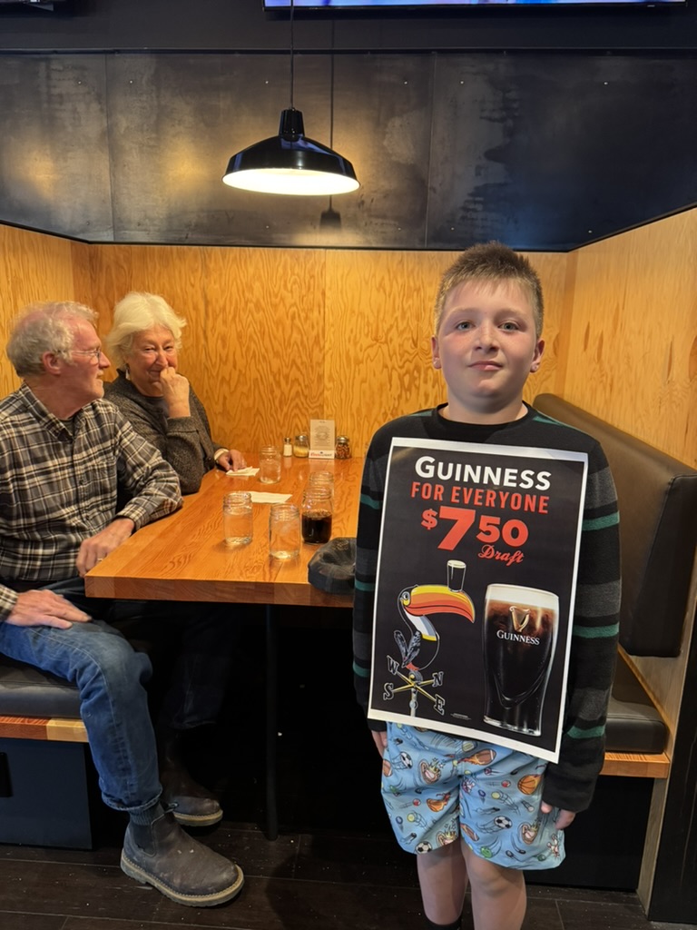 Wiley at a table at the celebration dinner, a Guinness poster on the wall behind him.